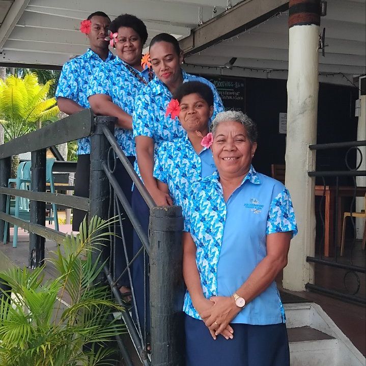 Resort staff in blue Pacific print uniforms on veranda